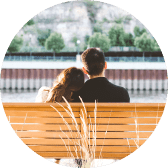 A man and a woman sitting on a wooden bench