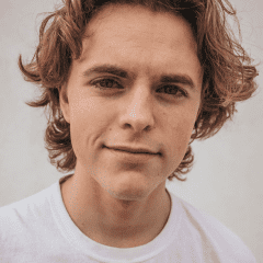 A man with long hair wearing a white shirt