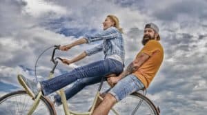 A man and a woman riding a bike together