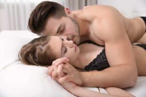 A man and a woman laying on a bed