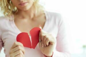 A woman holding a heart shaped piece of paper